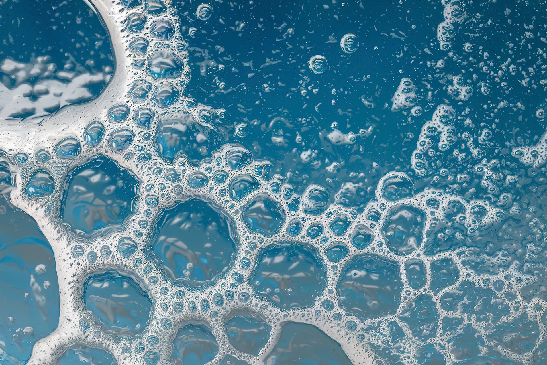 Un primo piano di bolle di sapone in un liquido blu