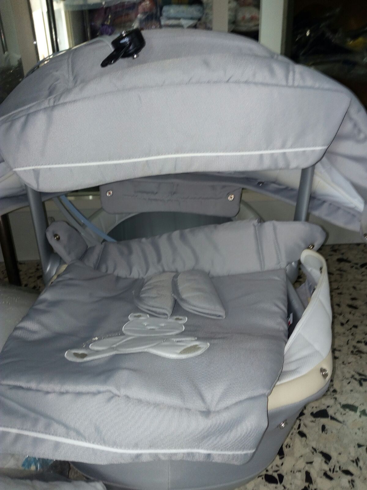 Una culla grigia con una barca a vela ricamata sopra