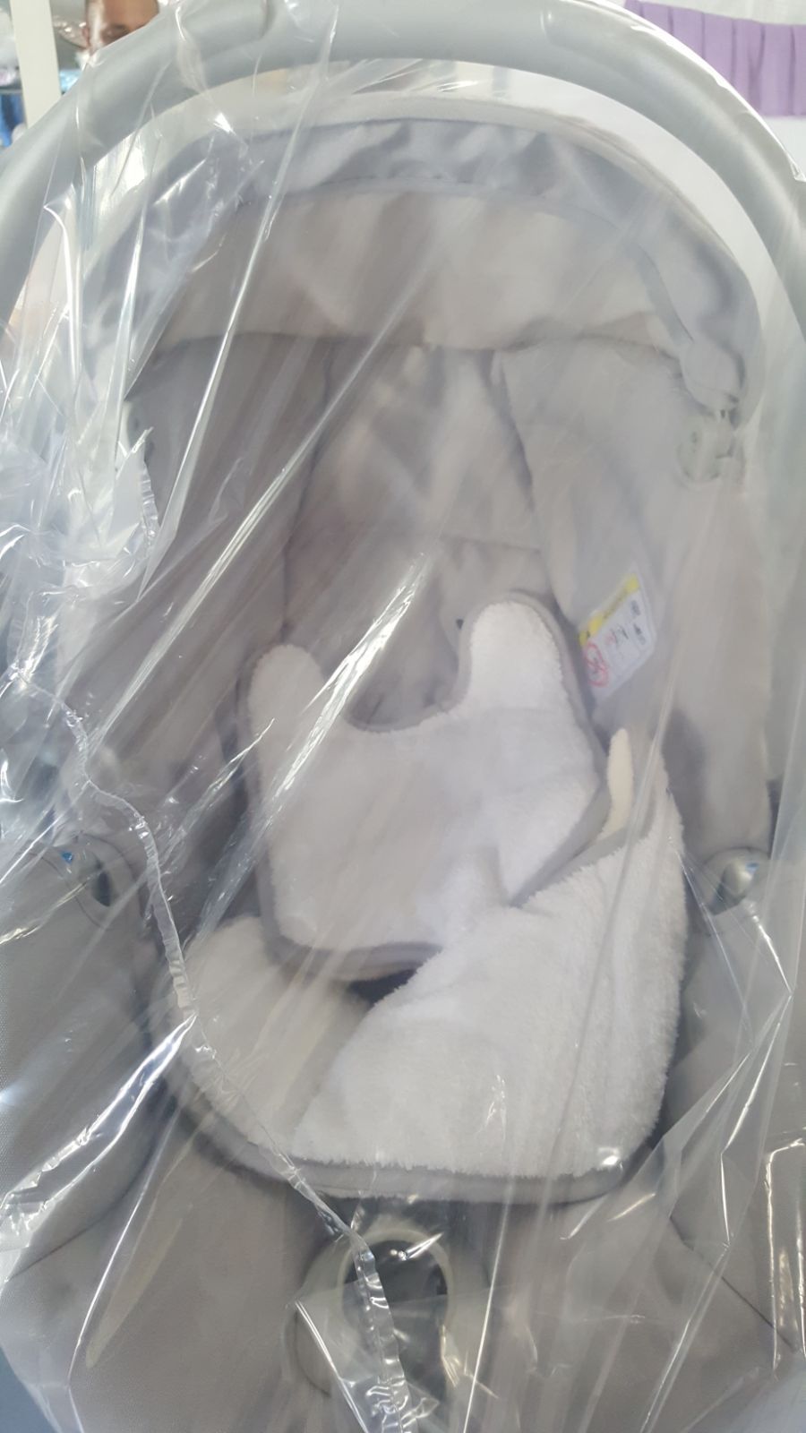 Un seggiolino per bambini è avvolto nella plastica e appoggiato su un tavolo.