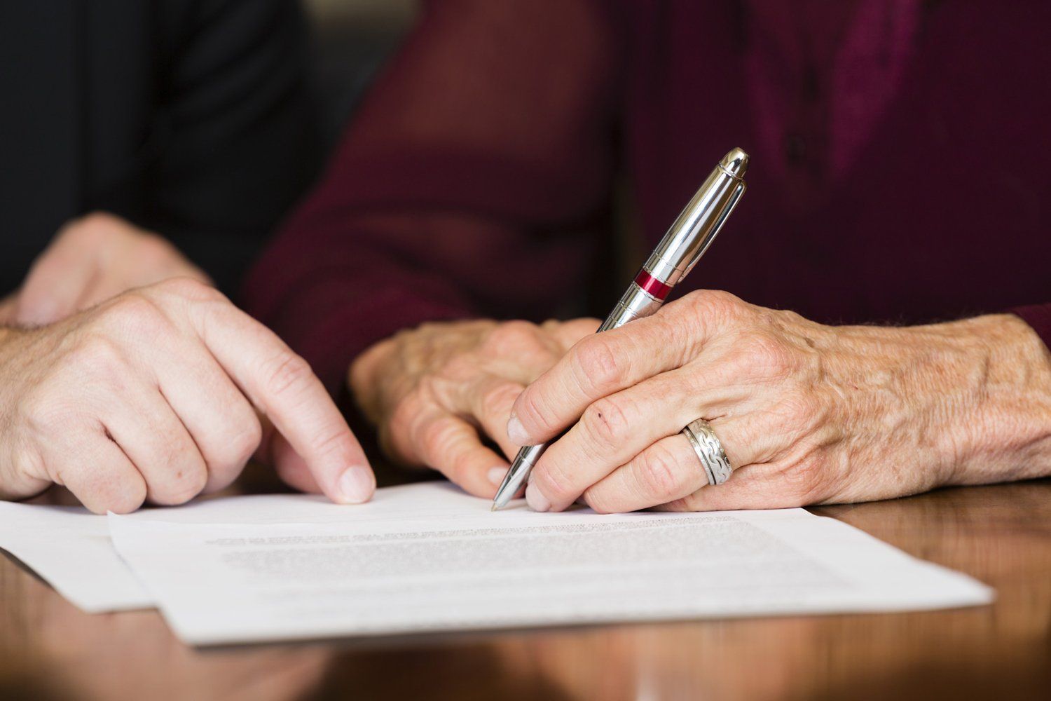 A senior citizen signing a document