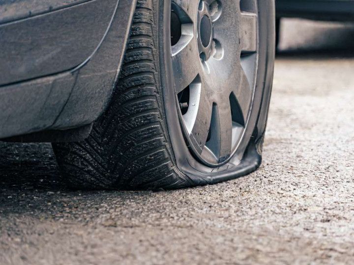 A close up of a flat tire on a car.
