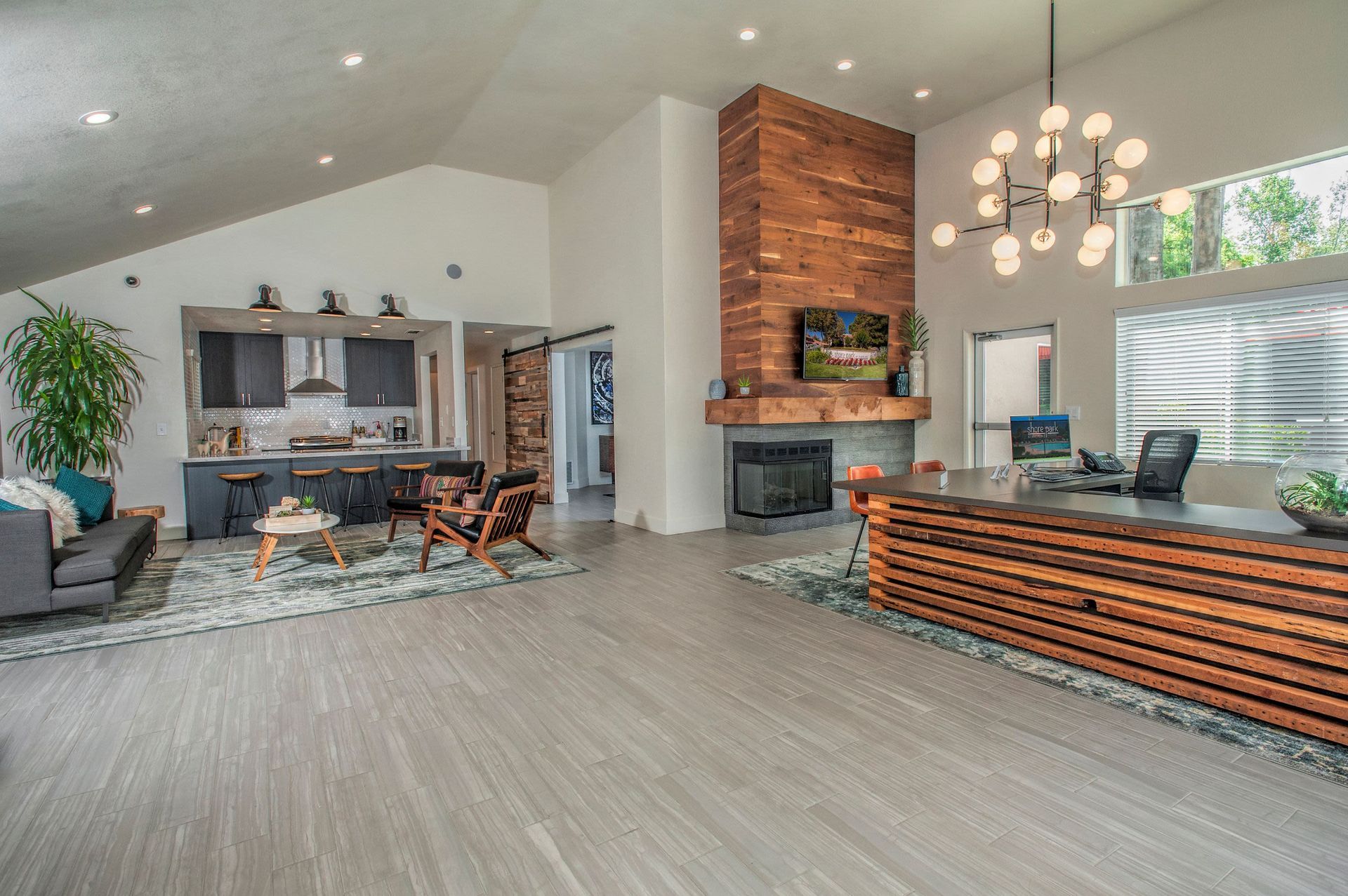 Spacious modern community lobby with reception desk, fireplace, and lounge seating.