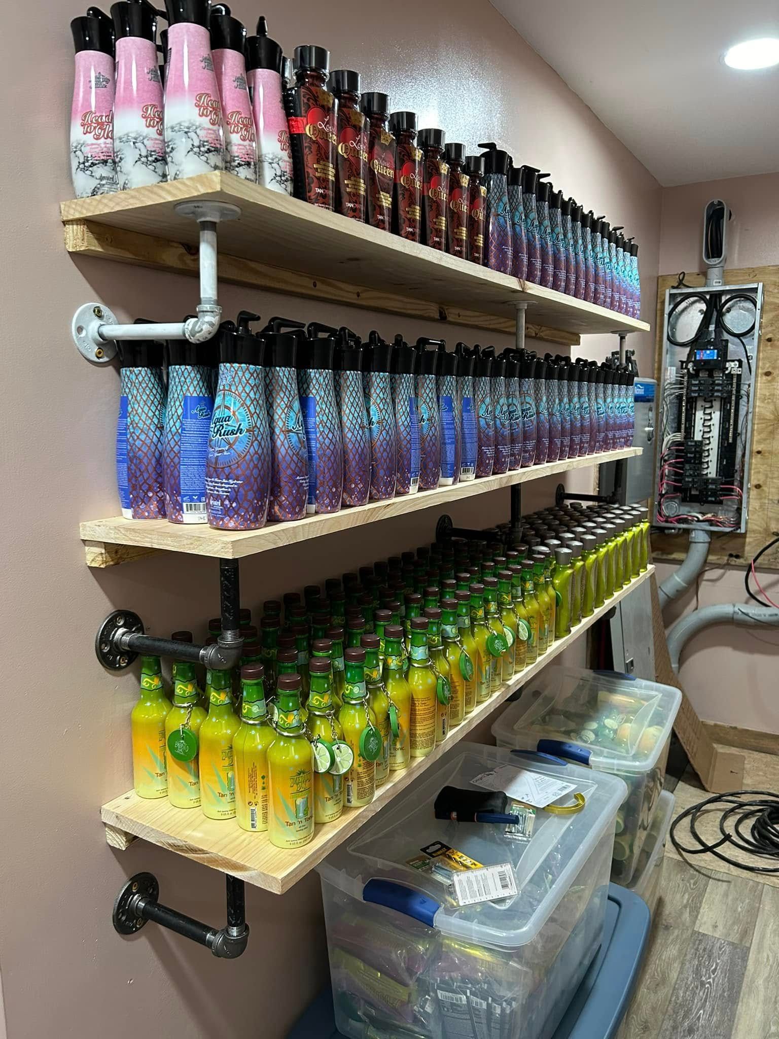 Three industrial-style wall shelves filled with rows of colorful water bottles, with plastic storage bins underneath.
