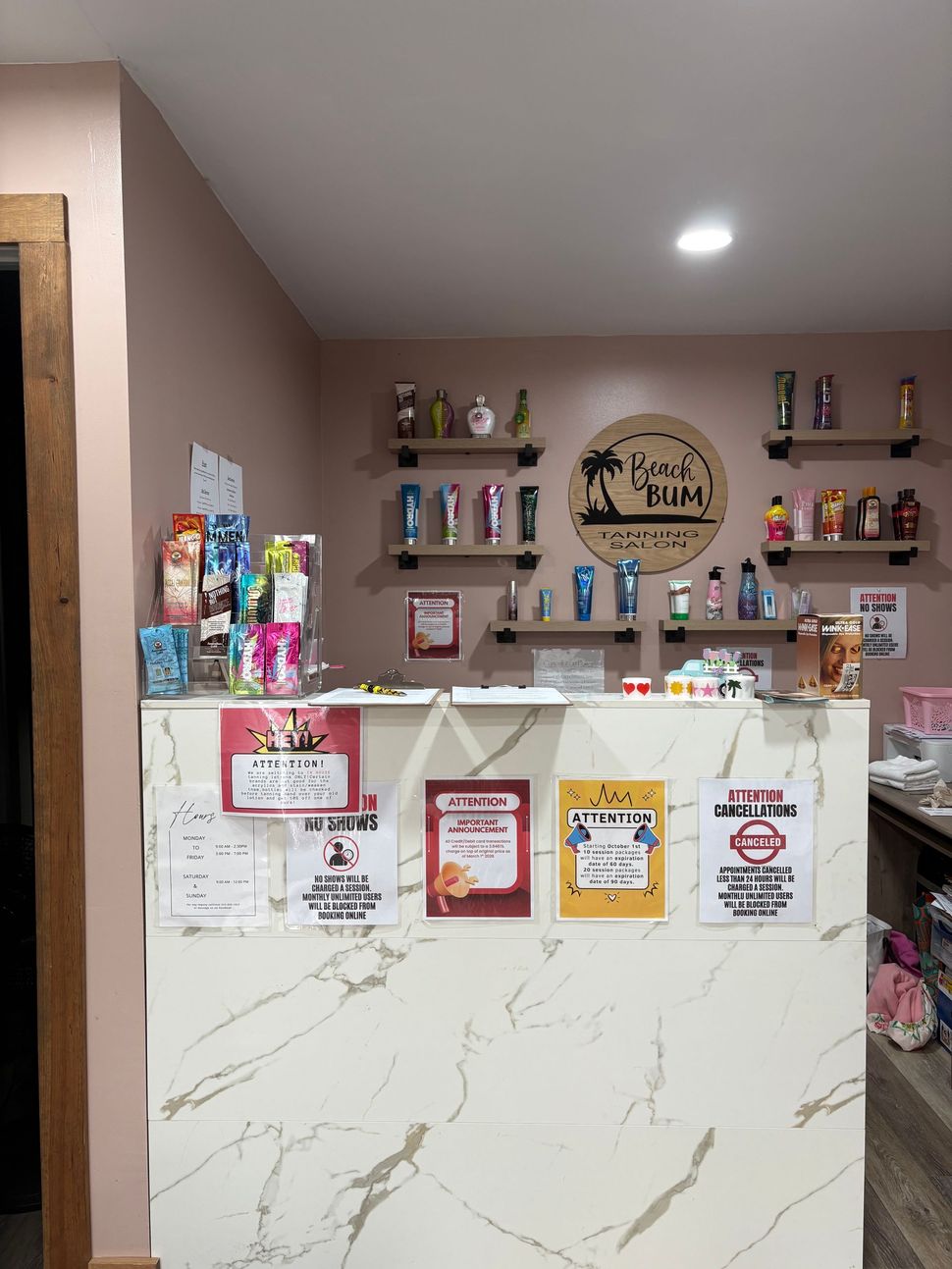 A reception area with a white marble desk, wood-look flooring, two white chairs, a water cooler, and decorative garland.