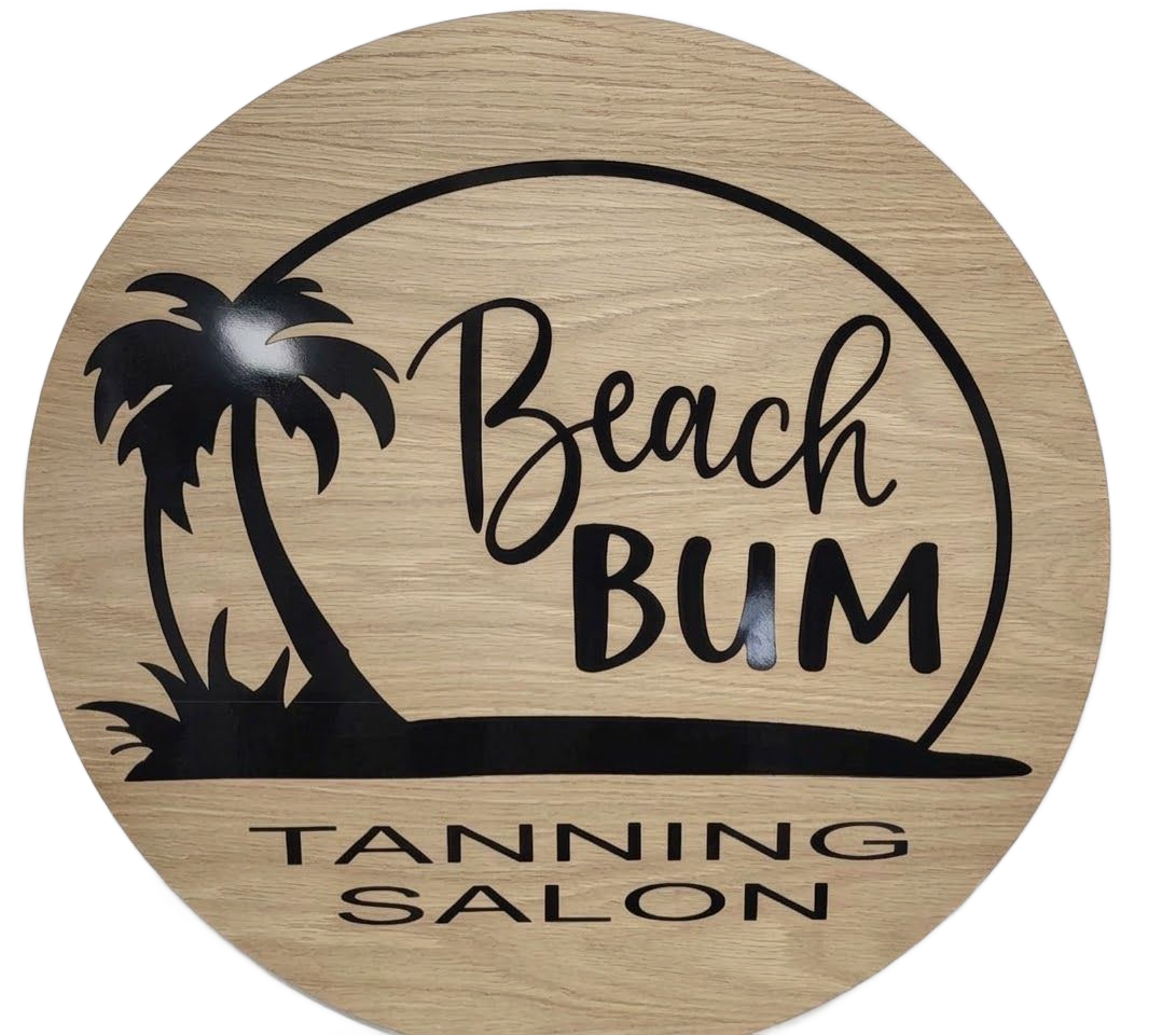 A round, wood-grain sign with a black palm tree silhouette and the text "Beach BUM TANNING SALON."