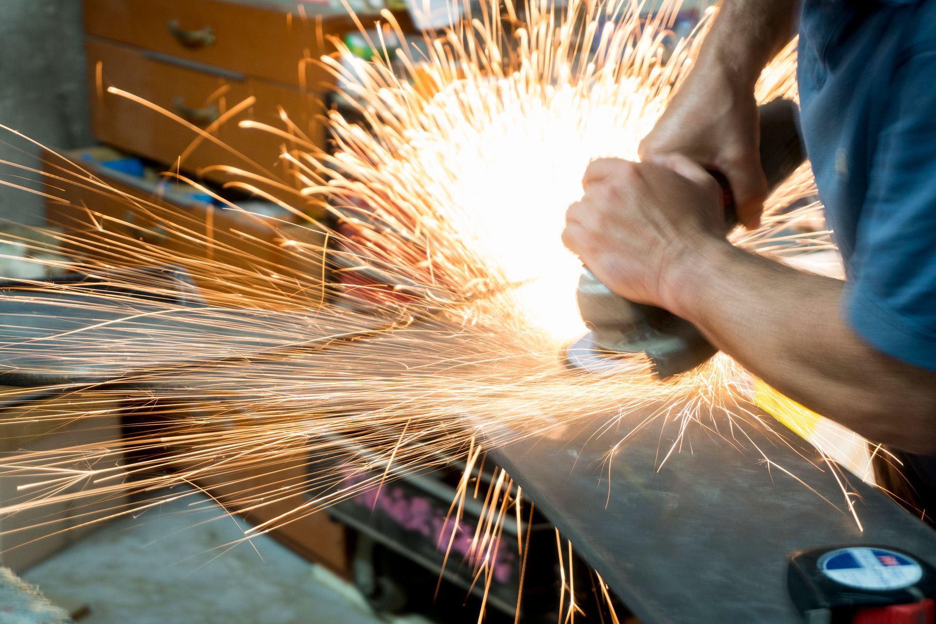 A skilled steelworker precisely cutting custom metal components with expert care. A skilled steelworker precisely cutting custom metal components with expert care.