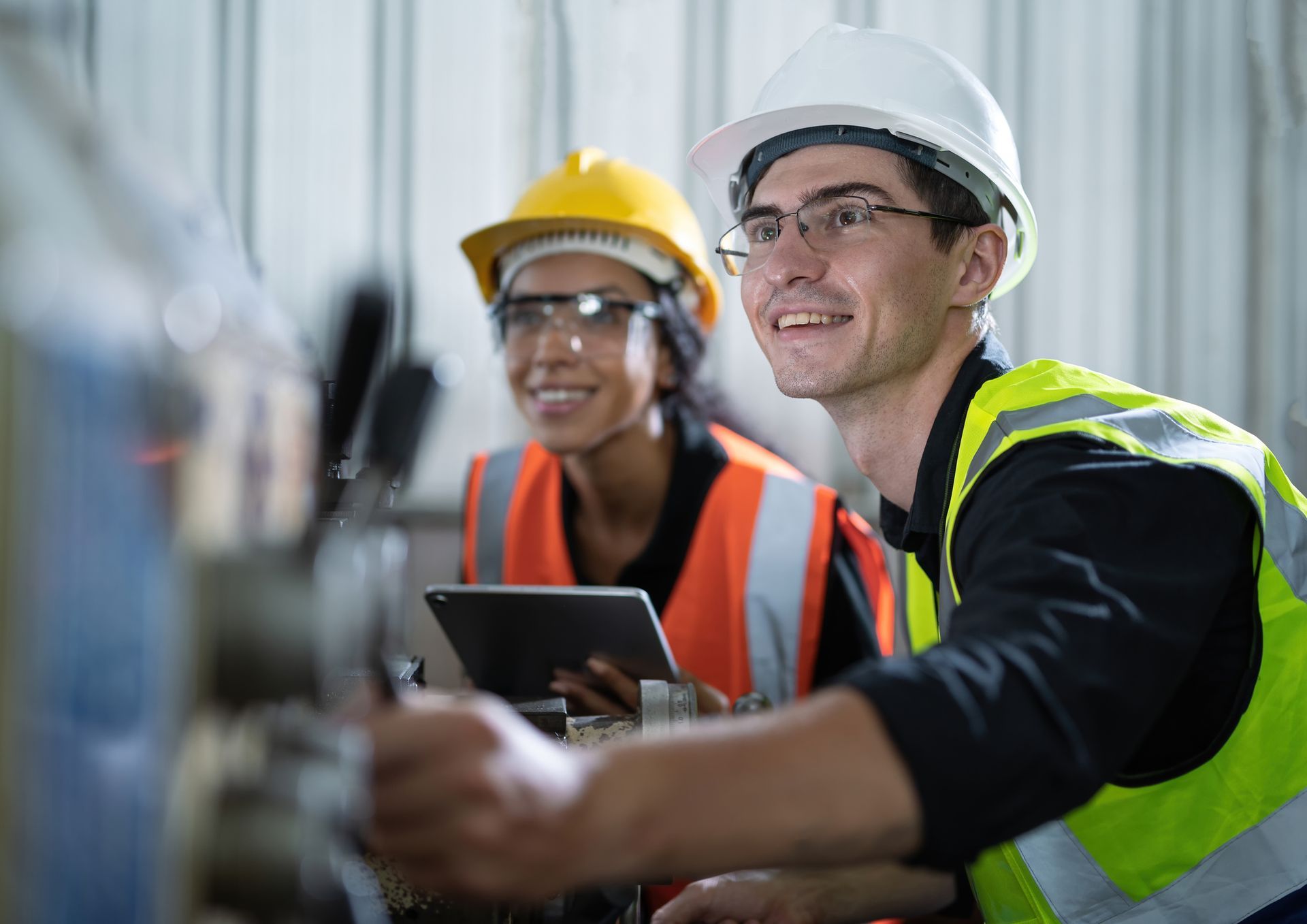 Male and female engineers operate steel lathe in manufacturing factory. Male and female engineers operate steel lathe in manufacturing factory.