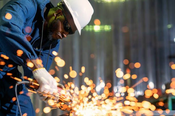 Steel Fabrication Technician grinding metal surface with tool 