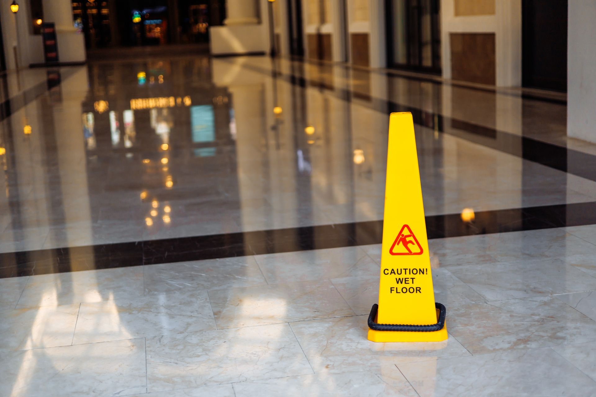 A yellow wet floor sign is sitting on the floor of a building.