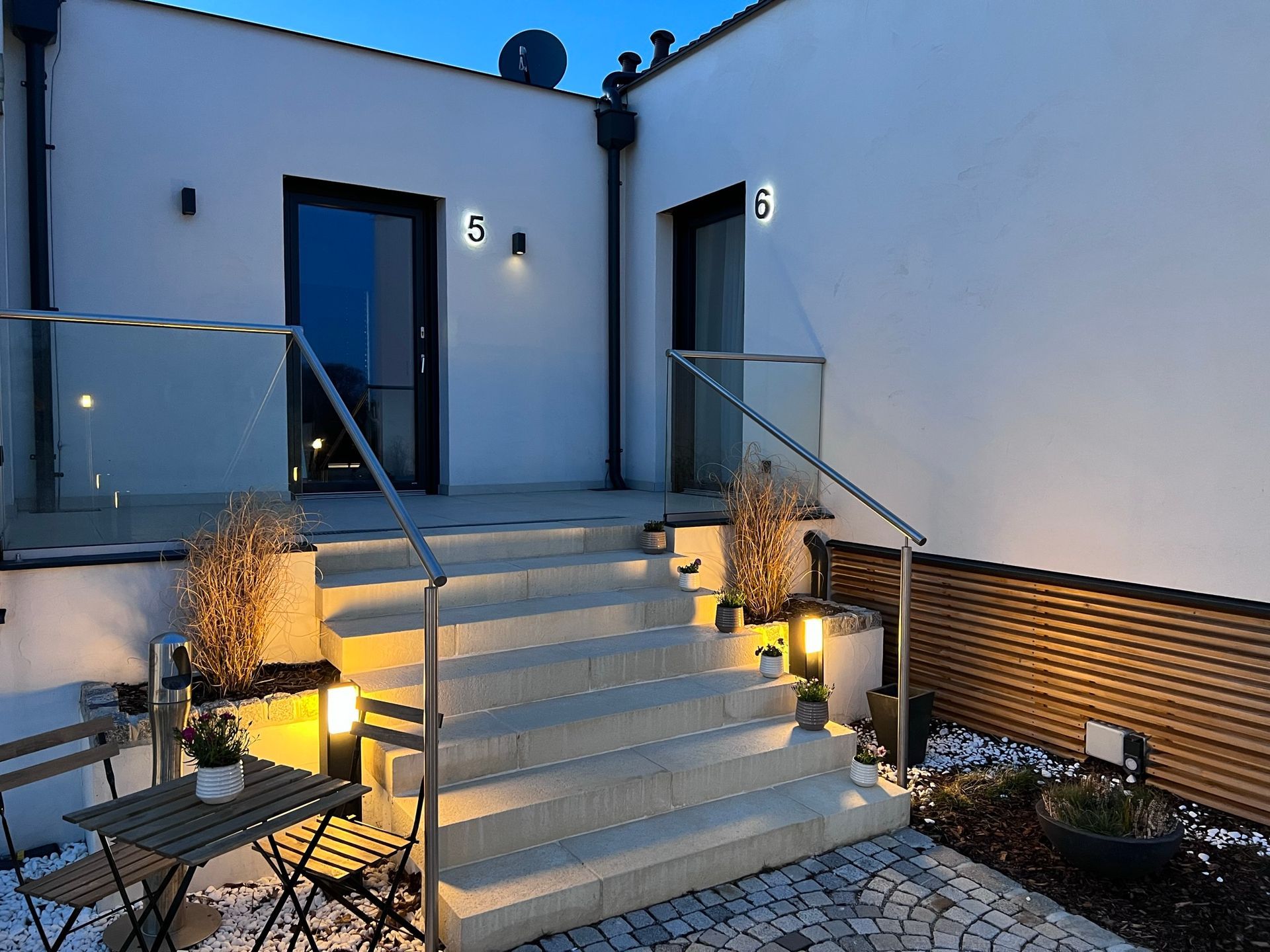 graue Stufen führen zum zweiten  Eingang 6. Beleuchtung entlang der Stufen spendet bei Dämmerung licht.