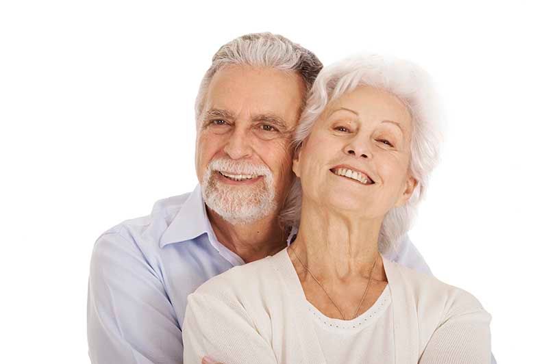 zufrieden lächelndes Seniorenpaar vor weißem Hintergrund, Stockfotografie