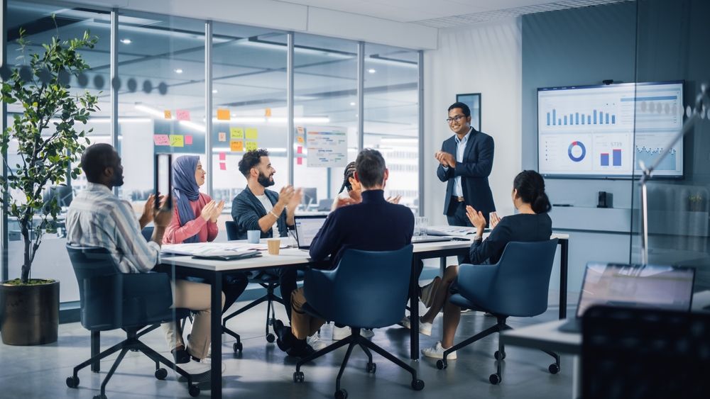 A man is giving a presentation to a group of people in a conference room.