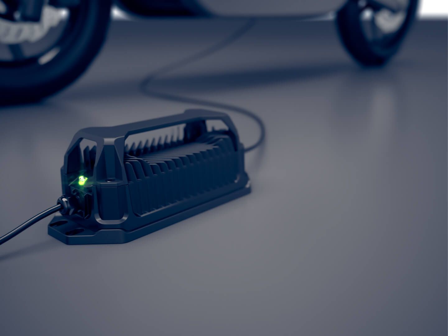 A motorcycle is being charged by a charger in a garage.