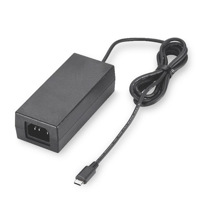 A black power supply is sitting on a white surface