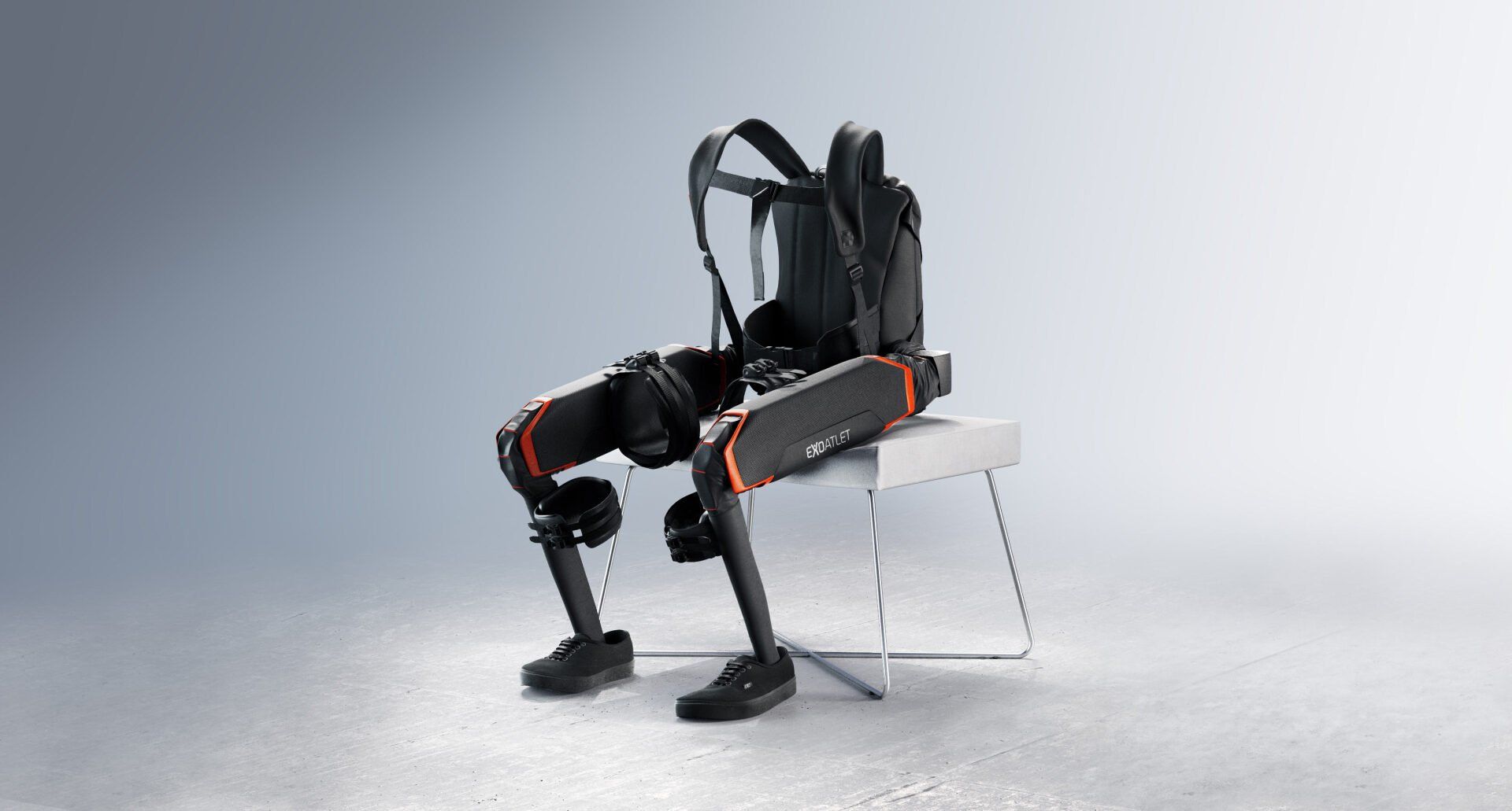 A robot exoskeleton  is sitting on a chair with a backpack on it.