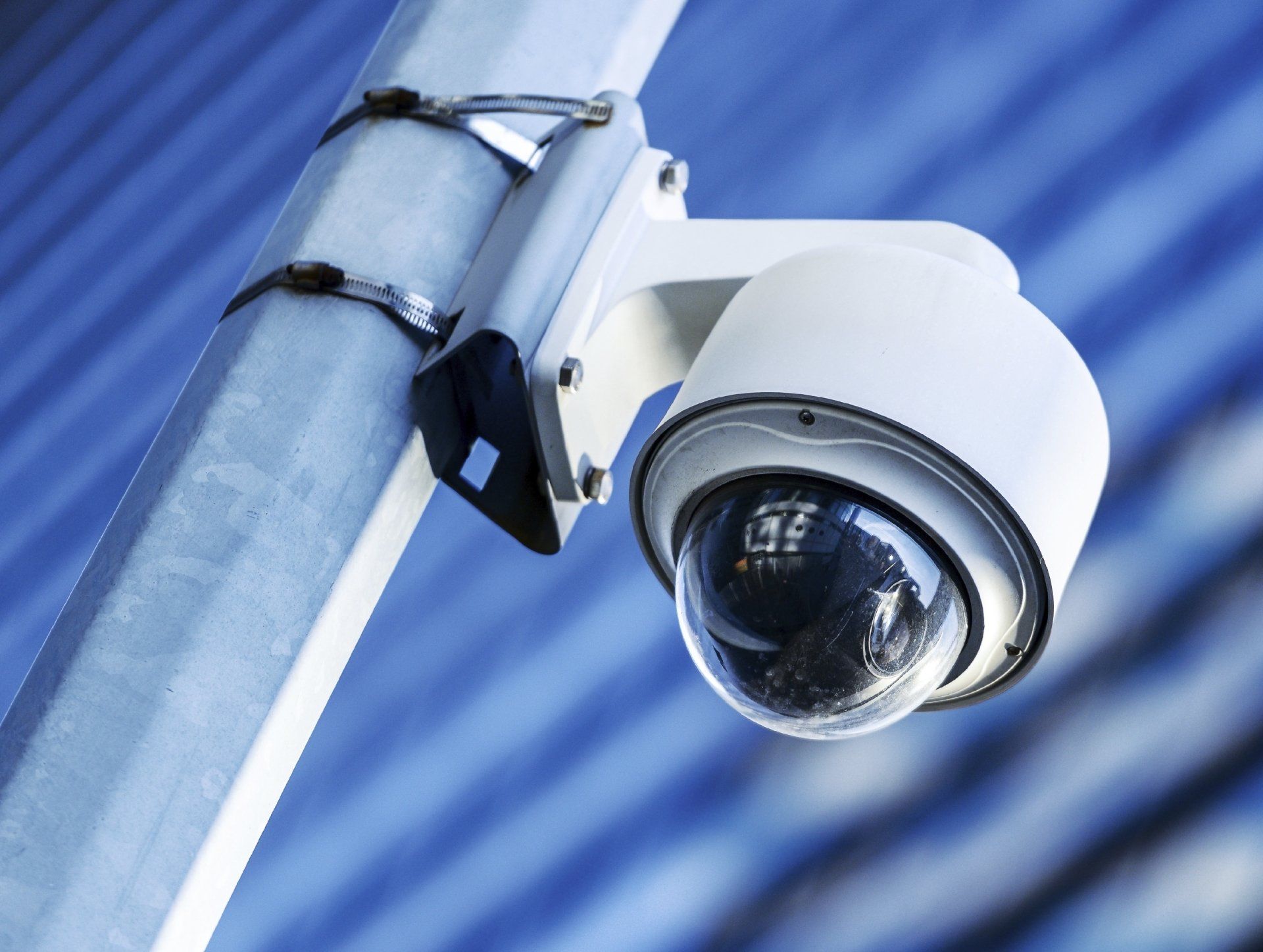 A security camera is mounted to a metal pole