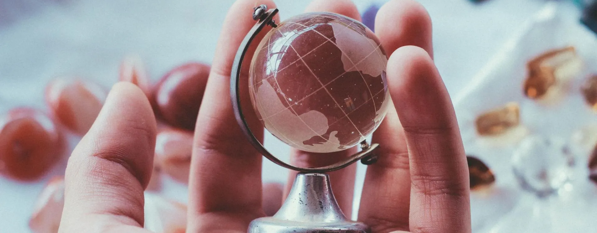 A person is holding a small globe in their hands.