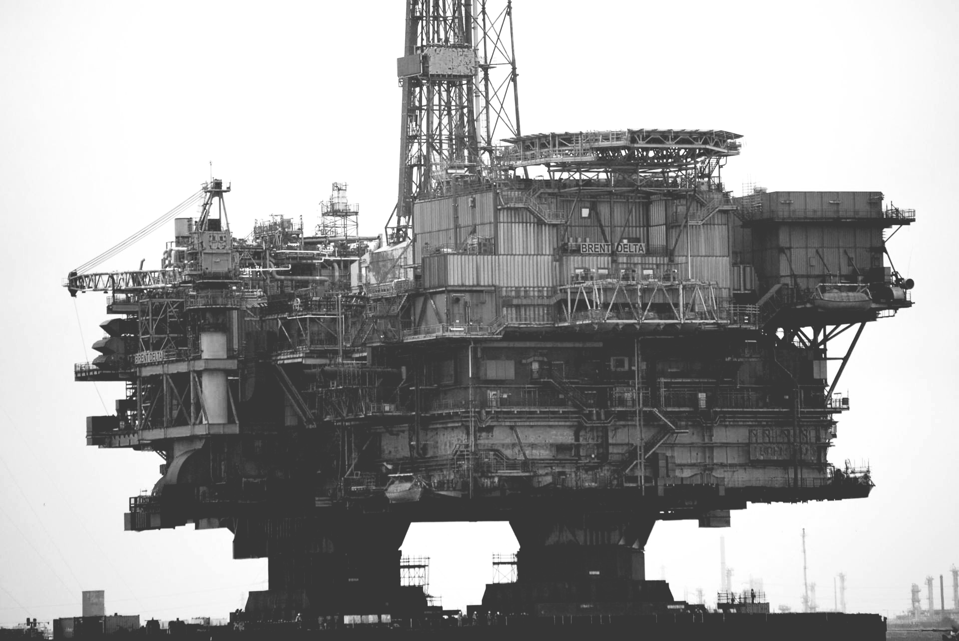 A black and white photo of an oil rig in the ocean.