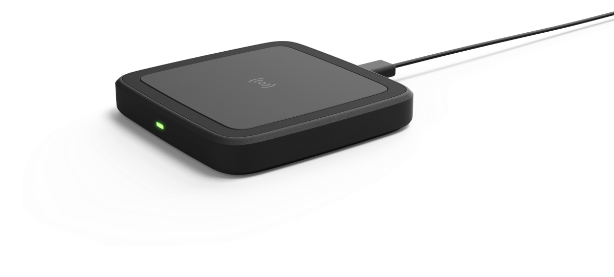 A black wireless charger is sitting on a white surface.