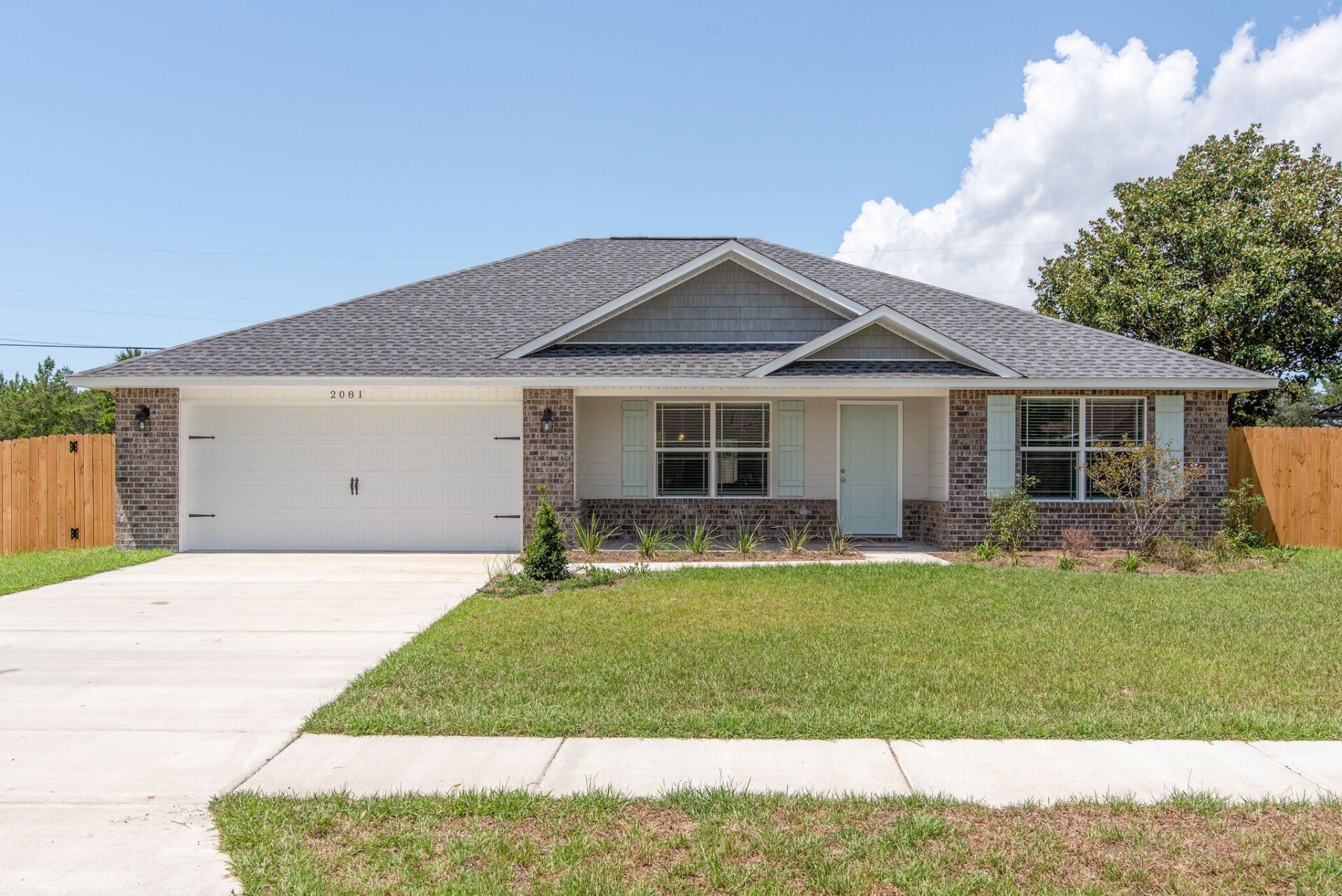 Exterior Photo of a House with a garage and green lawn