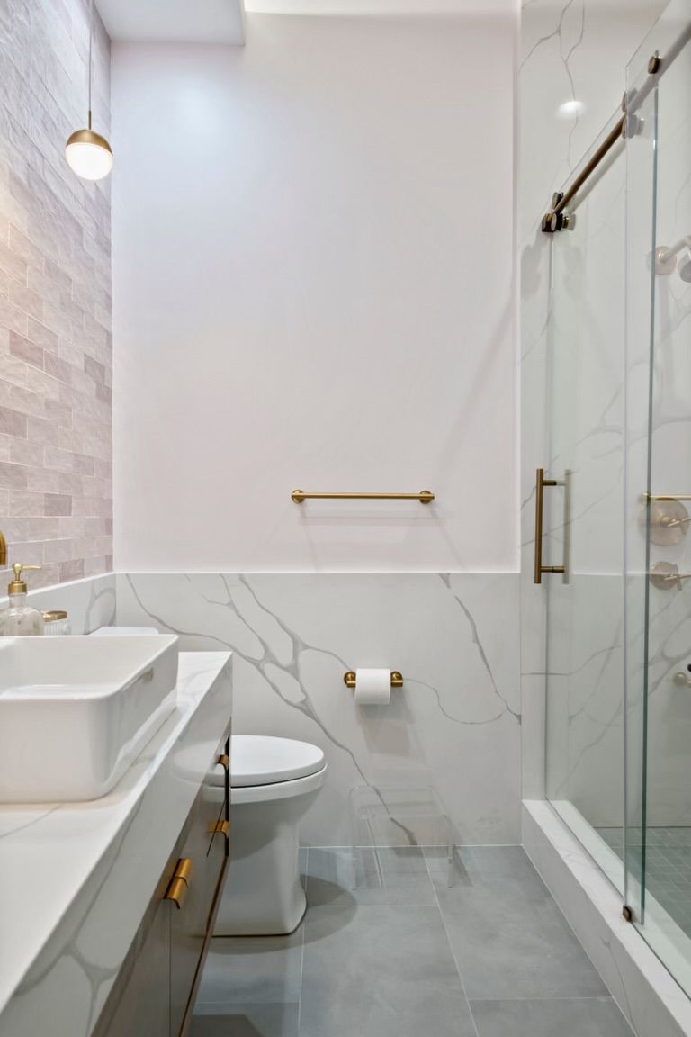 A bathroom with a toilet , sink , and shower.