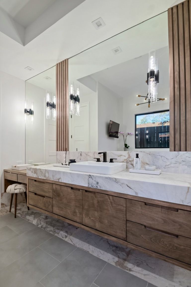 A bathroom with two sinks and a large mirror.