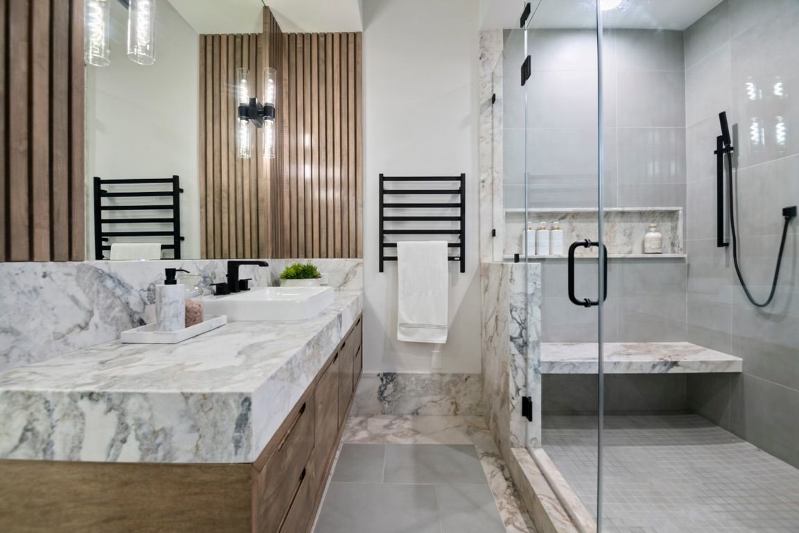 A bathroom with two sinks and a walk in shower.