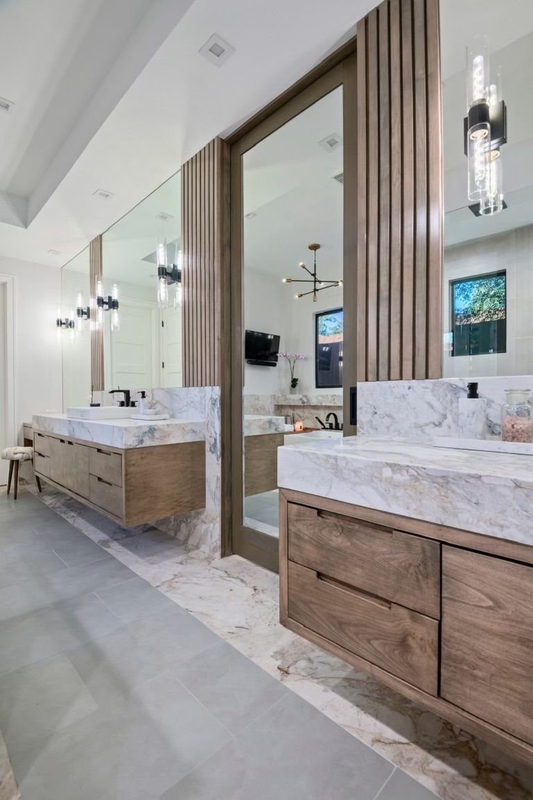 A bathroom with two sinks and a large mirror.