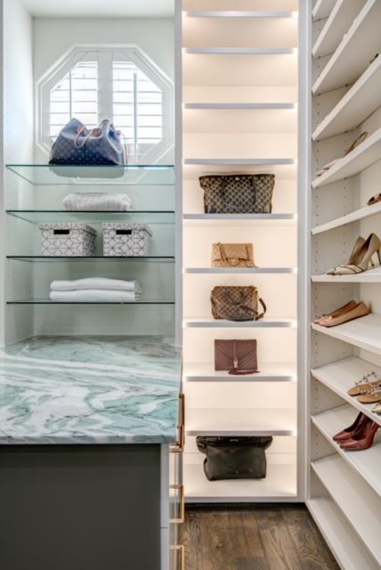 A walk in closet with shelves filled with handbags and shoes.