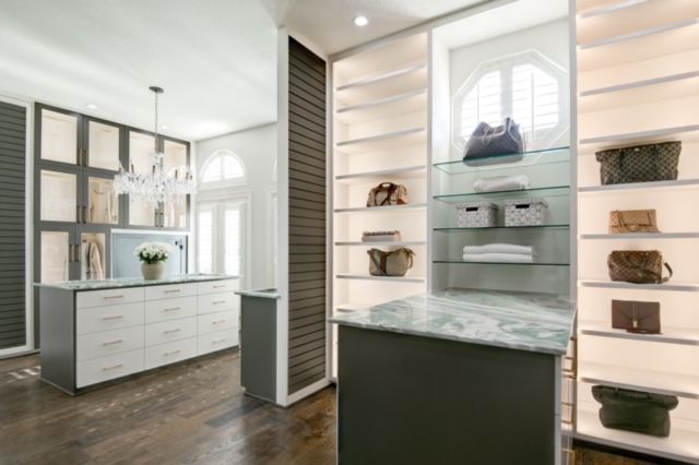 A walk in closet with lots of shelves and handbags on them