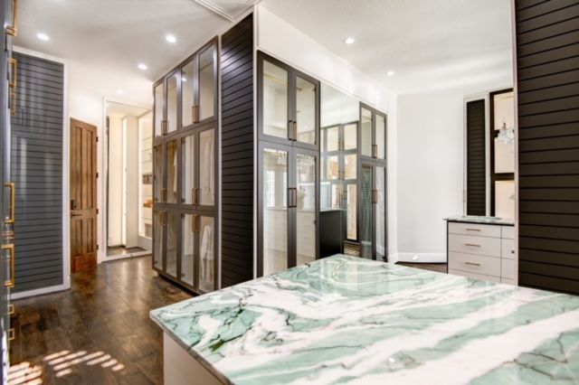 A large walk in closet with a marble counter top.
