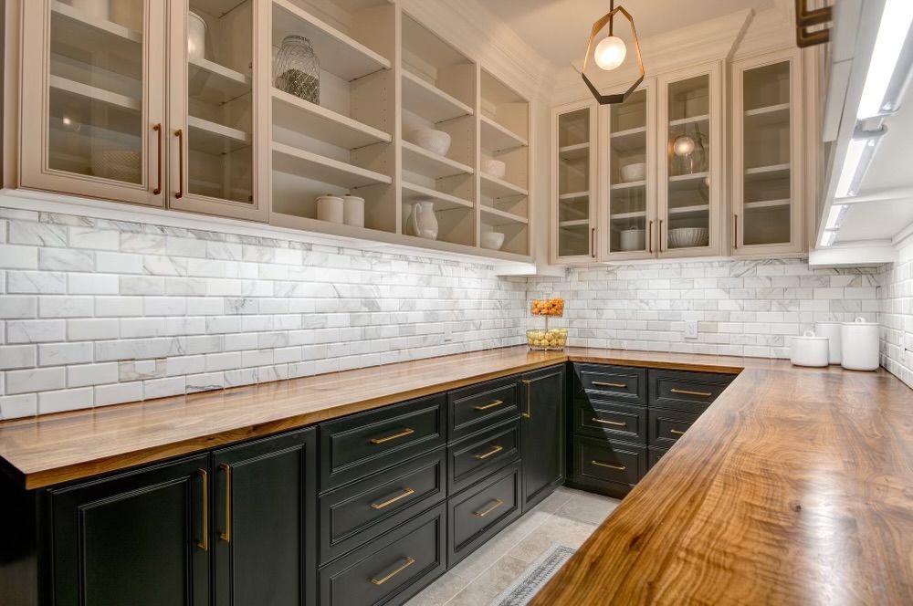 A kitchen with black cabinets and wooden counter tops.