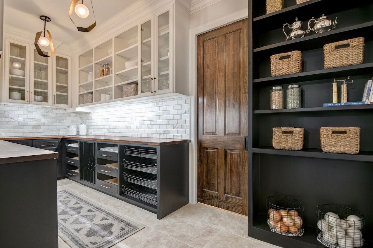 A kitchen with lots of cabinets and shelves and a pantry.