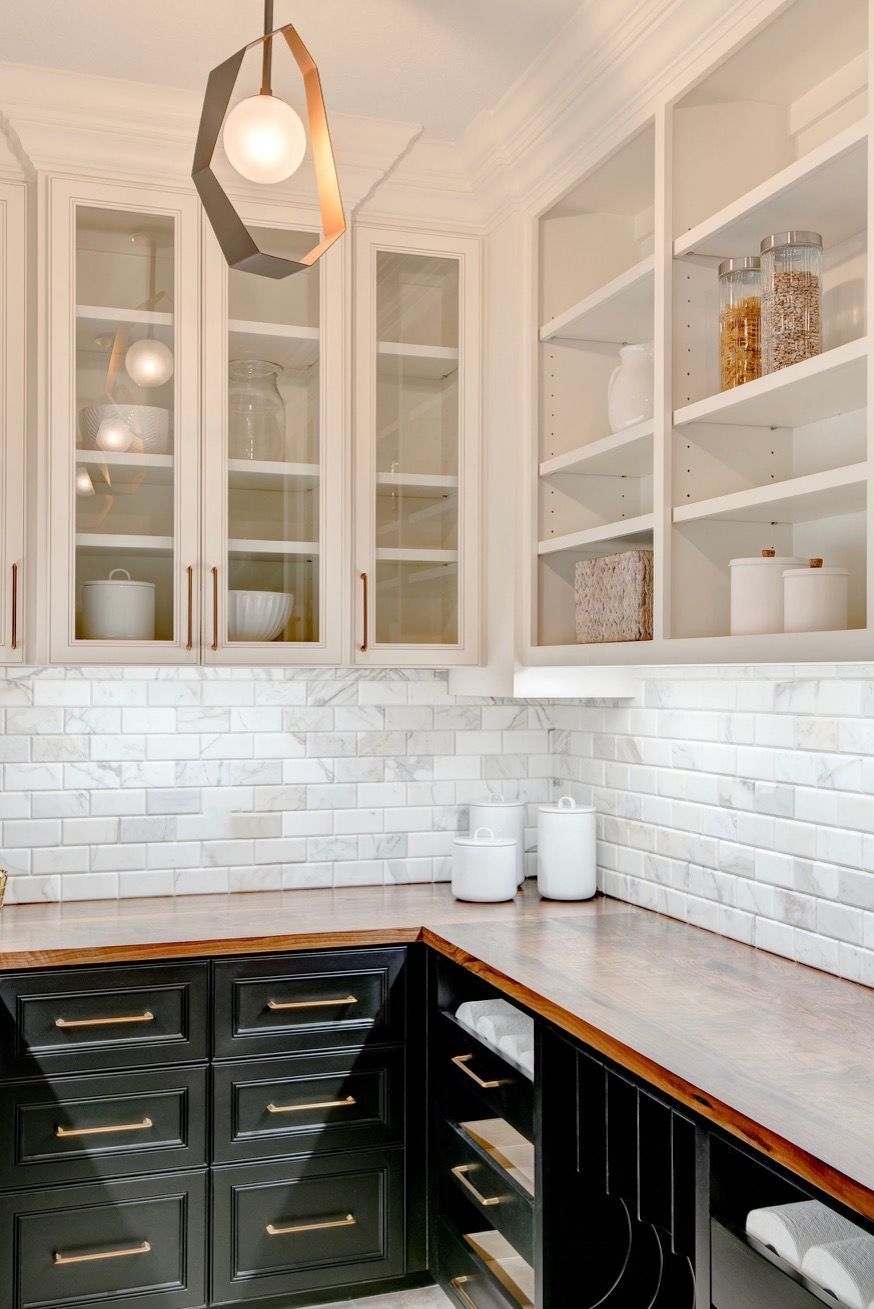 A kitchen with black cabinets and white cabinets and shelves.