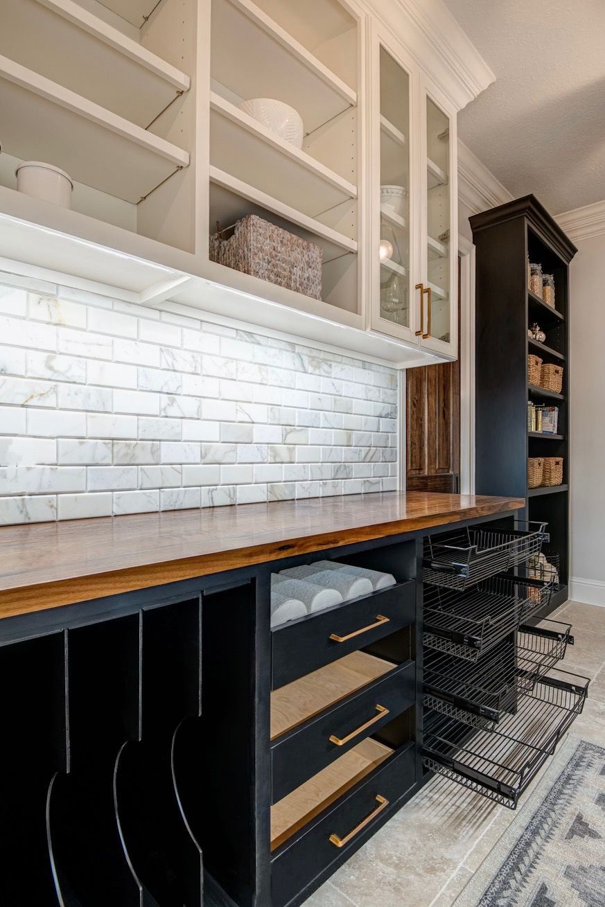 A kitchen with lots of cabinets and drawers and a brick wall.