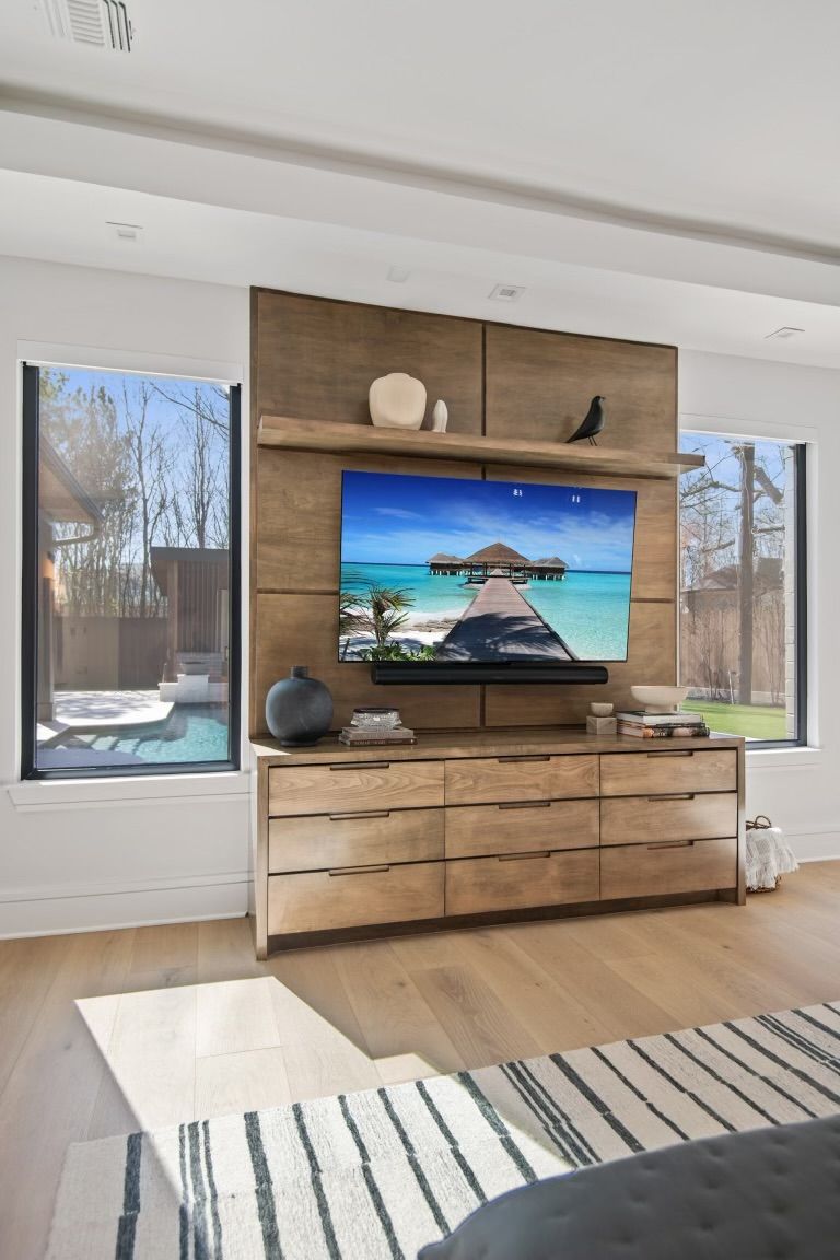 A living room with a flat screen tv mounted to the wall.