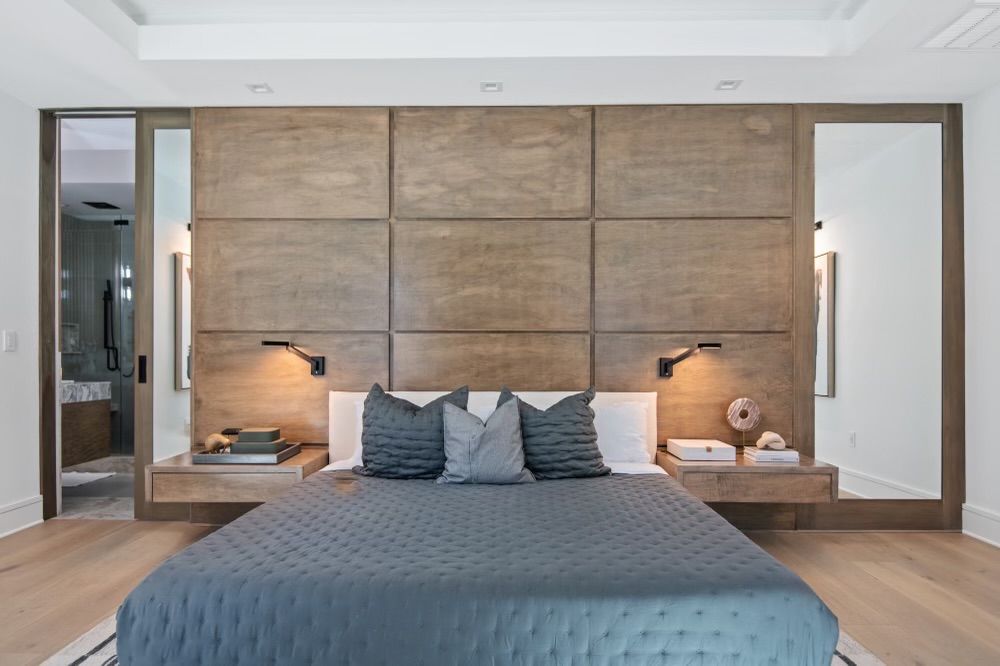 A bedroom with a large bed and a wooden headboard.