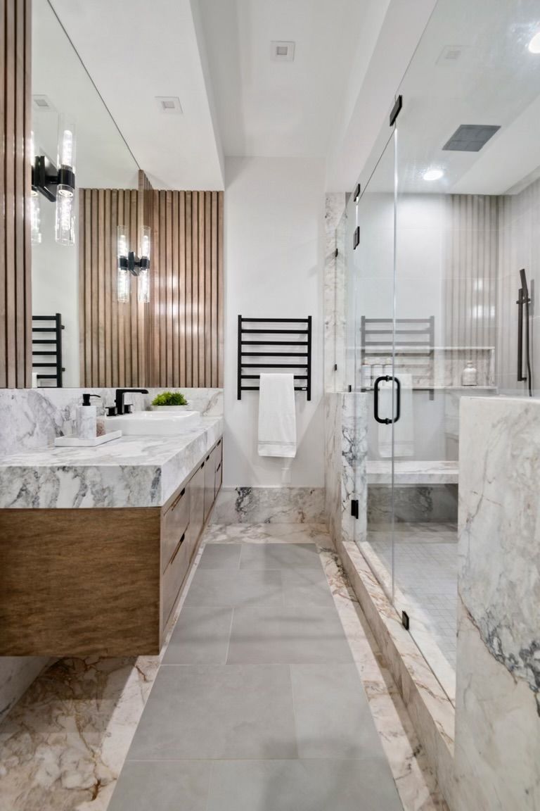 A bathroom with two sinks , a walk in shower and a large mirror.