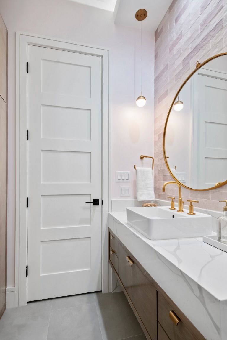 A bathroom with two sinks , a mirror and a door.