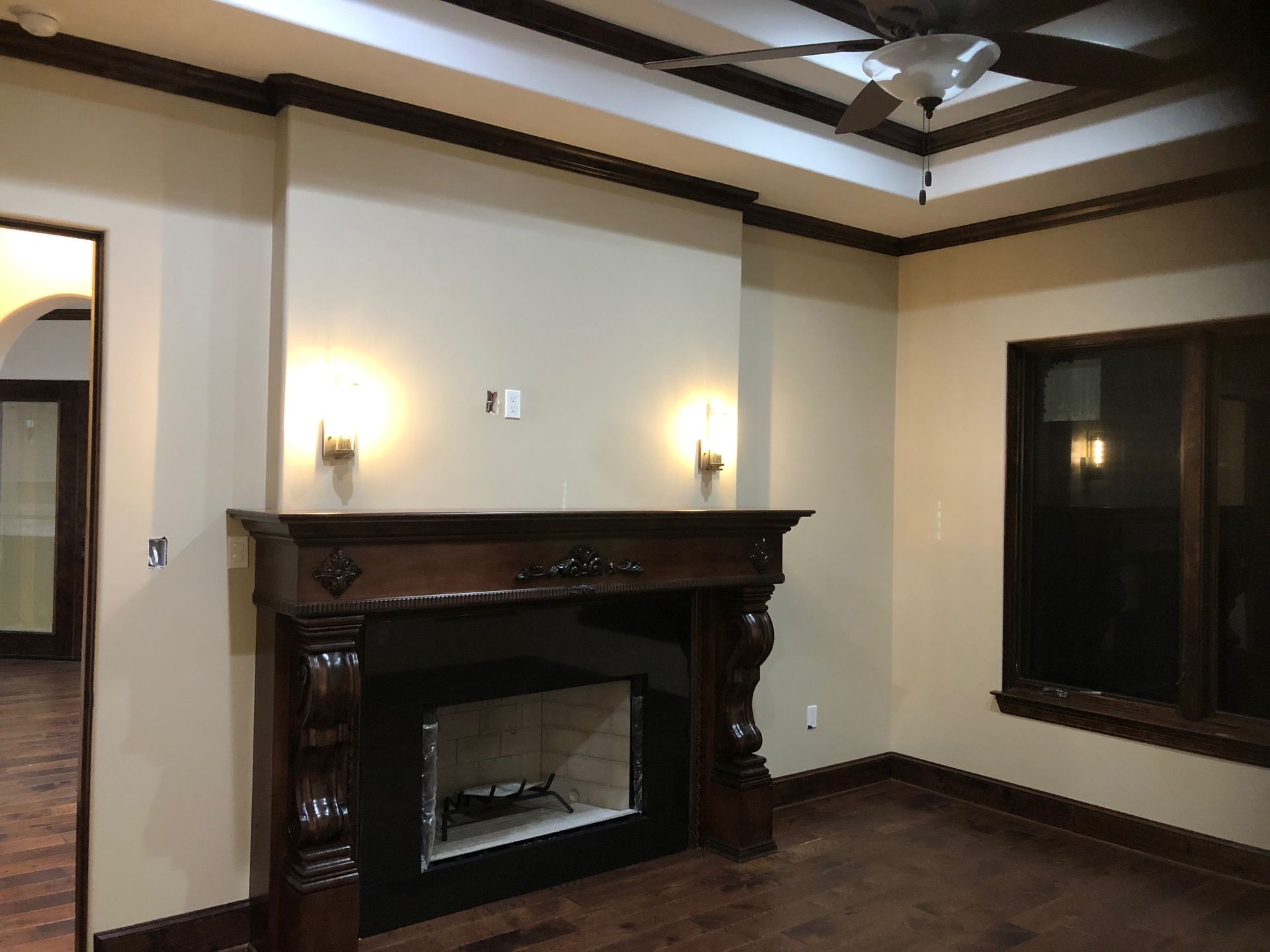 A living room with a fireplace and a ceiling fan