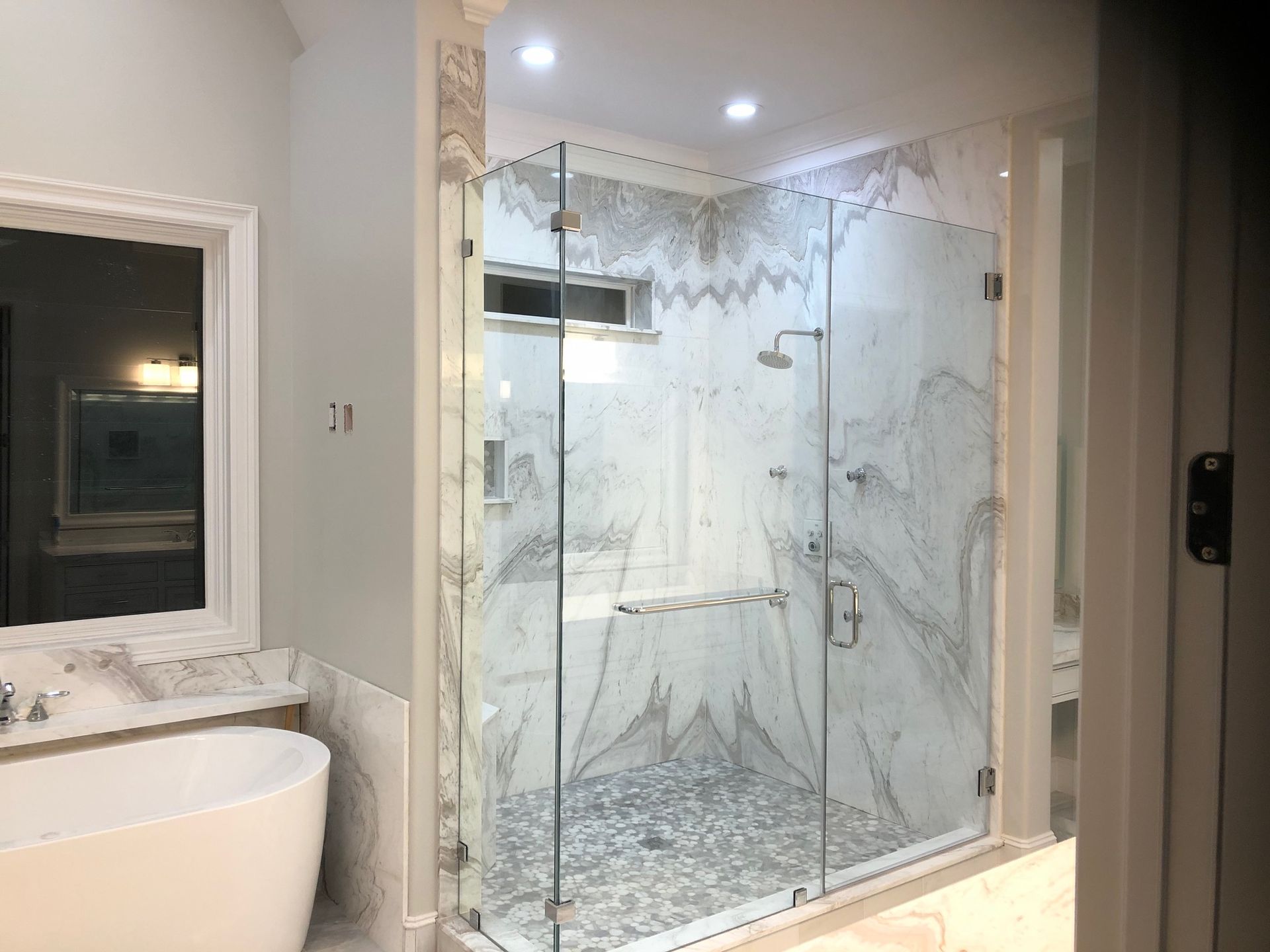 A bathroom with a walk in shower and a bathtub.