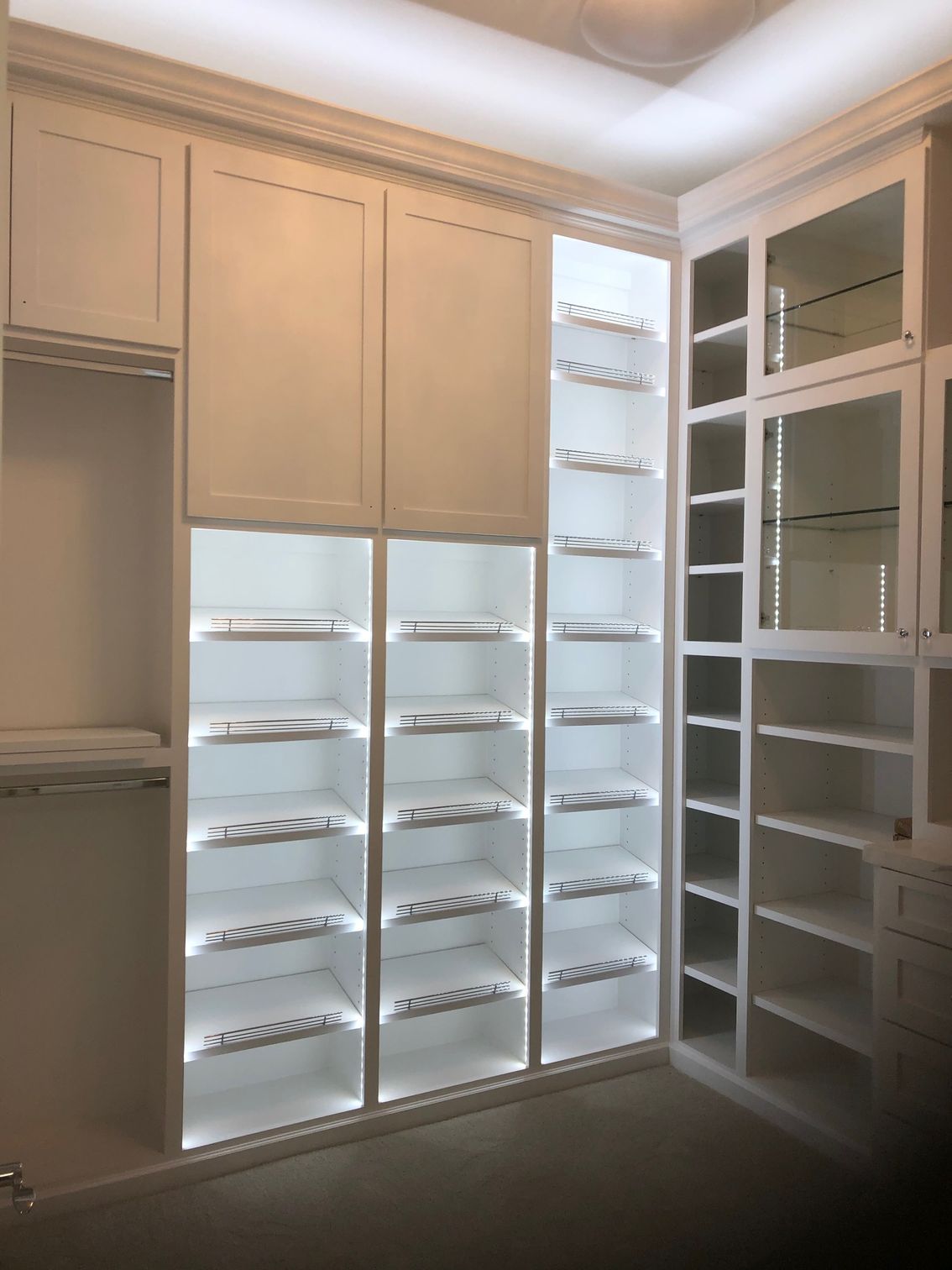 A walk in closet with lots of shelves and cabinets