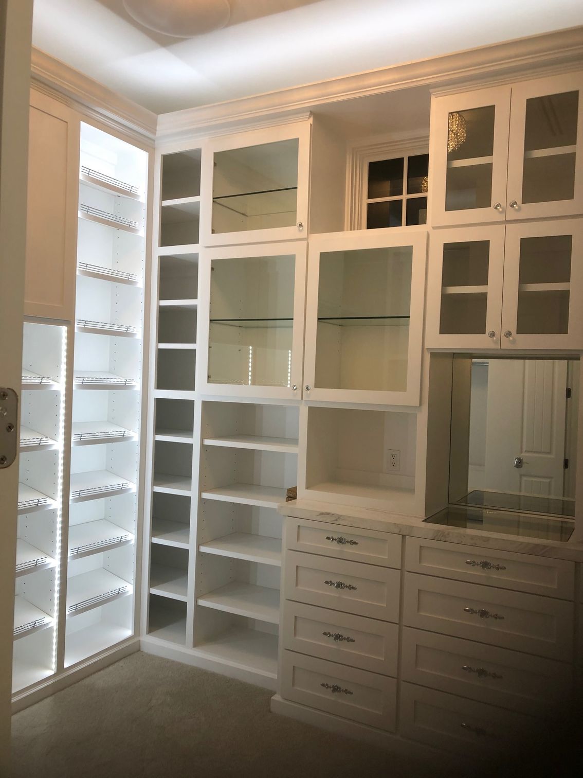 A walk in closet with lots of shelves and drawers