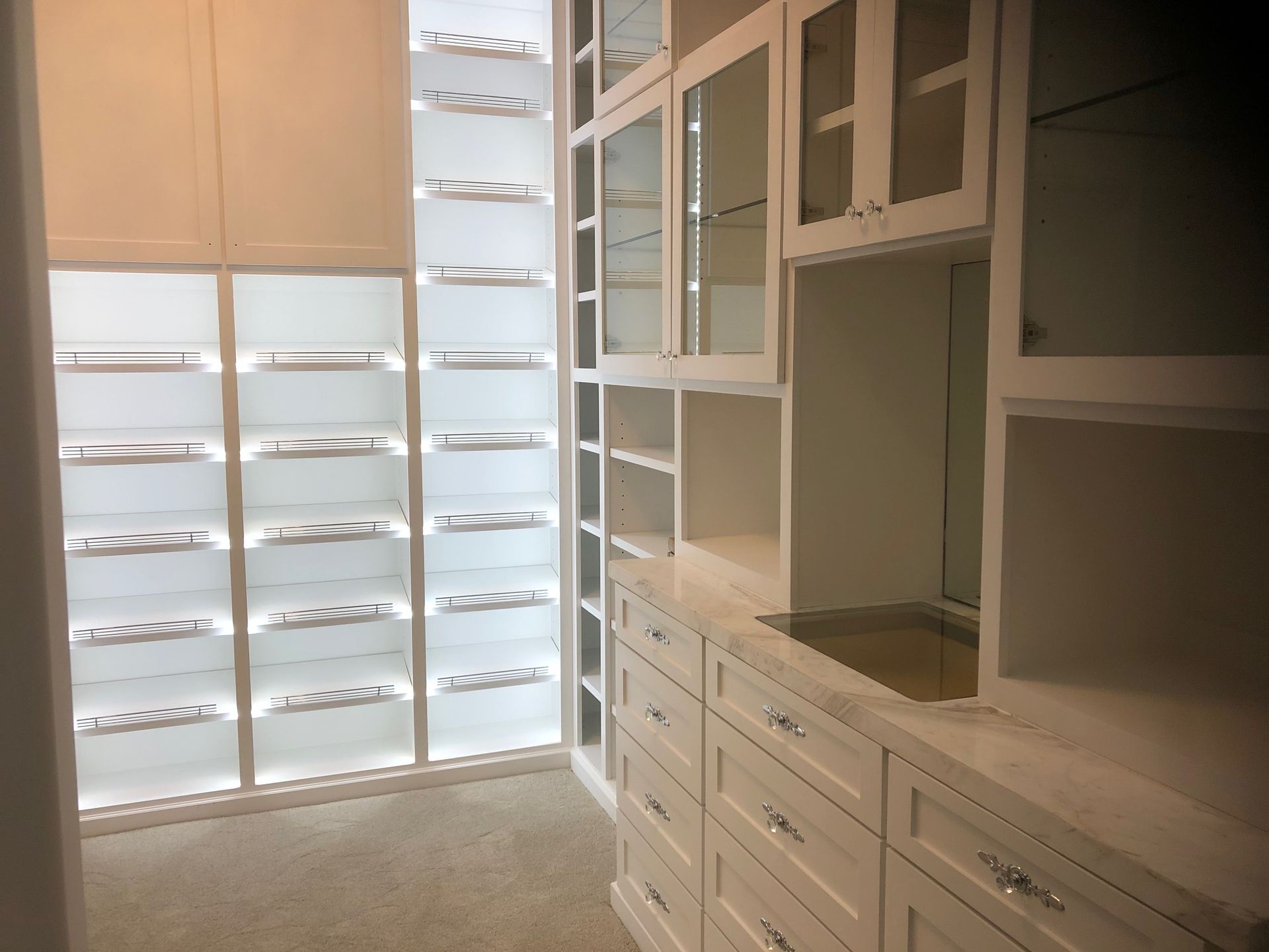 A walk in closet with lots of shelves and drawers