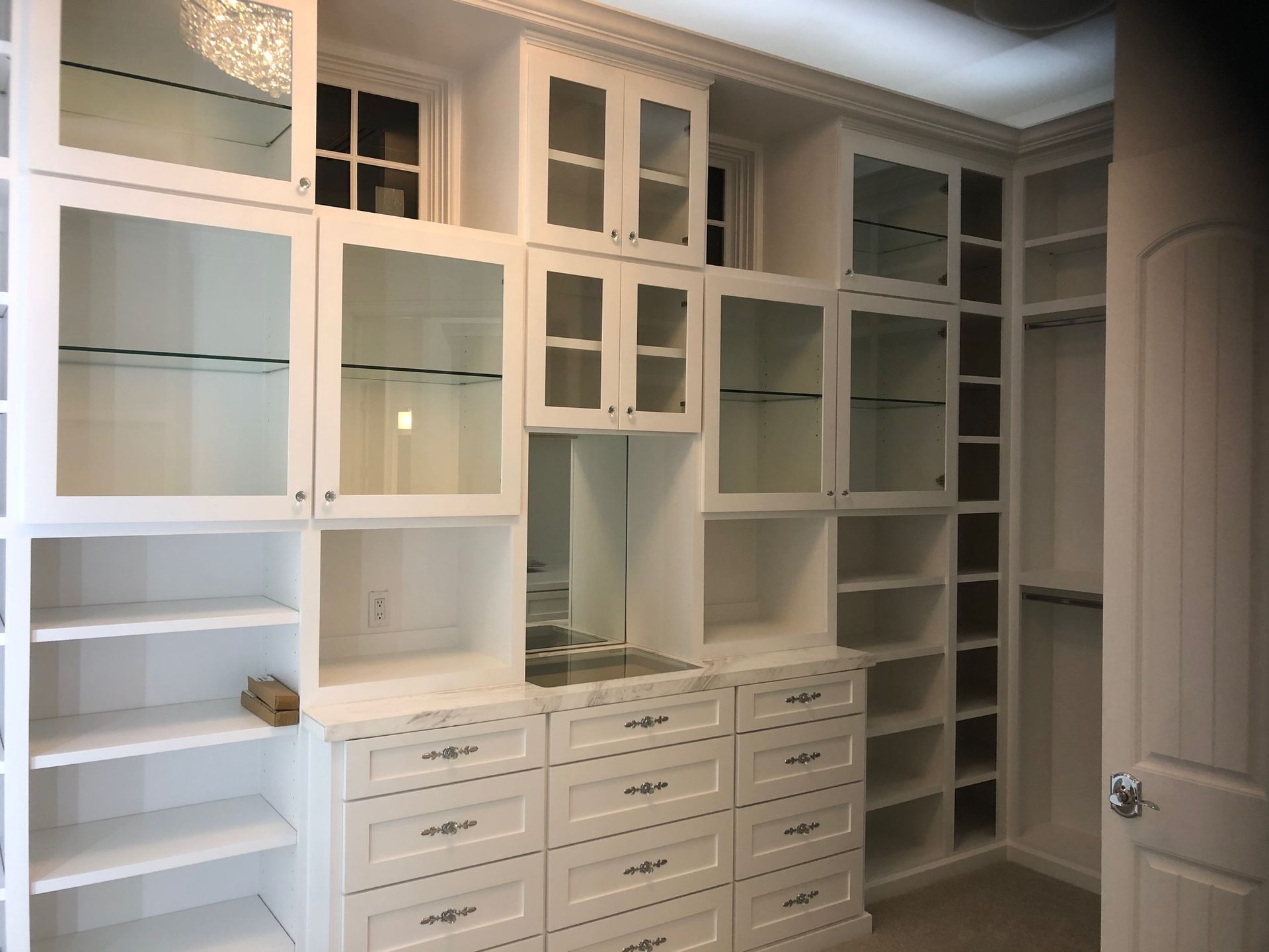 A walk in closet with lots of shelves and drawers
