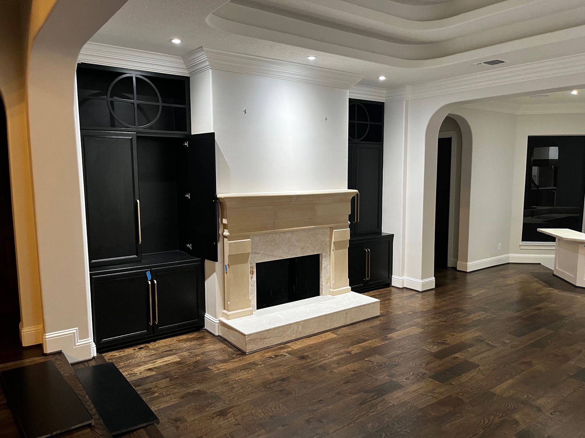A living room with a fireplace and black cabinets