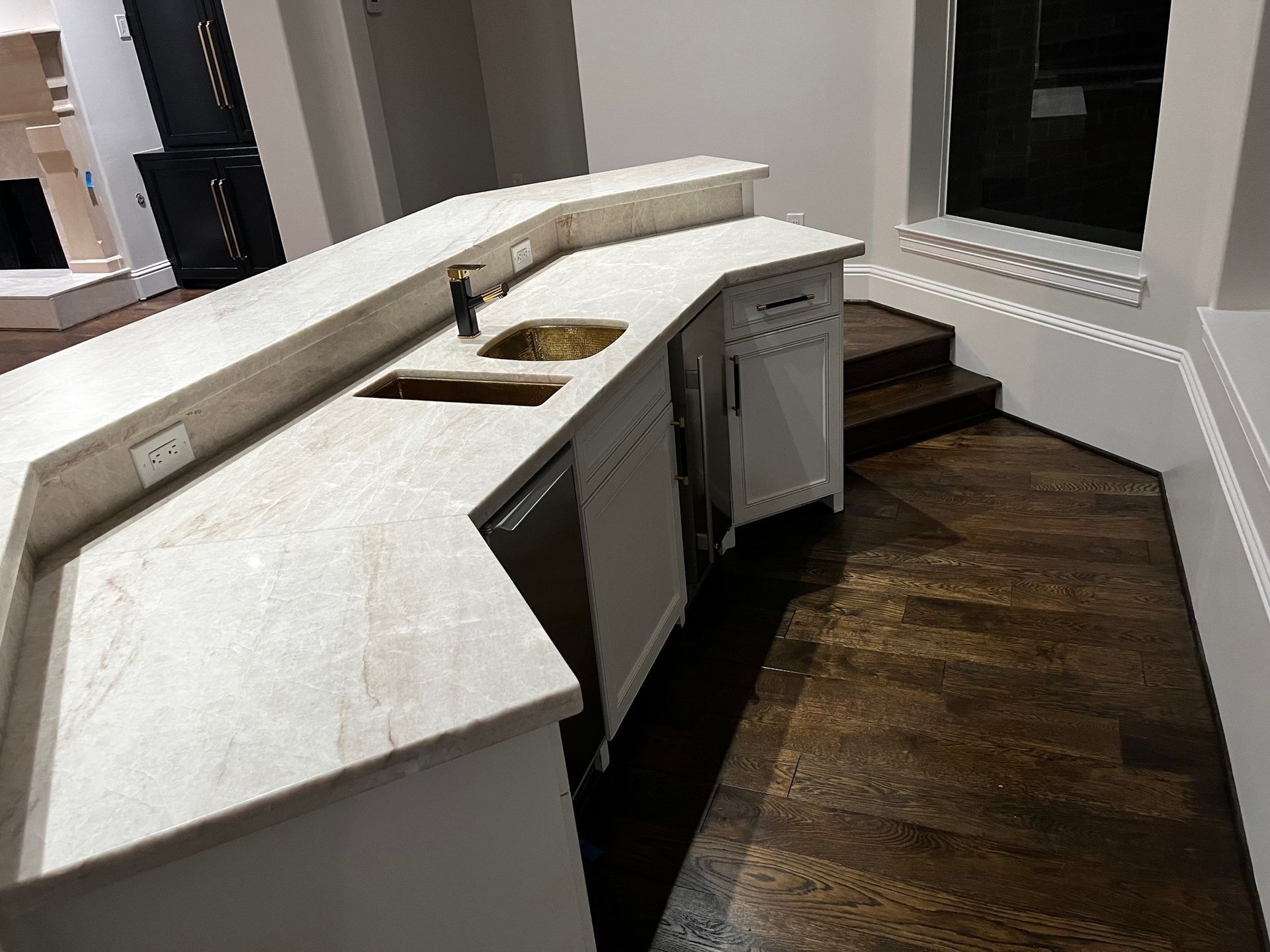 A kitchen with a curved counter top and a sink.