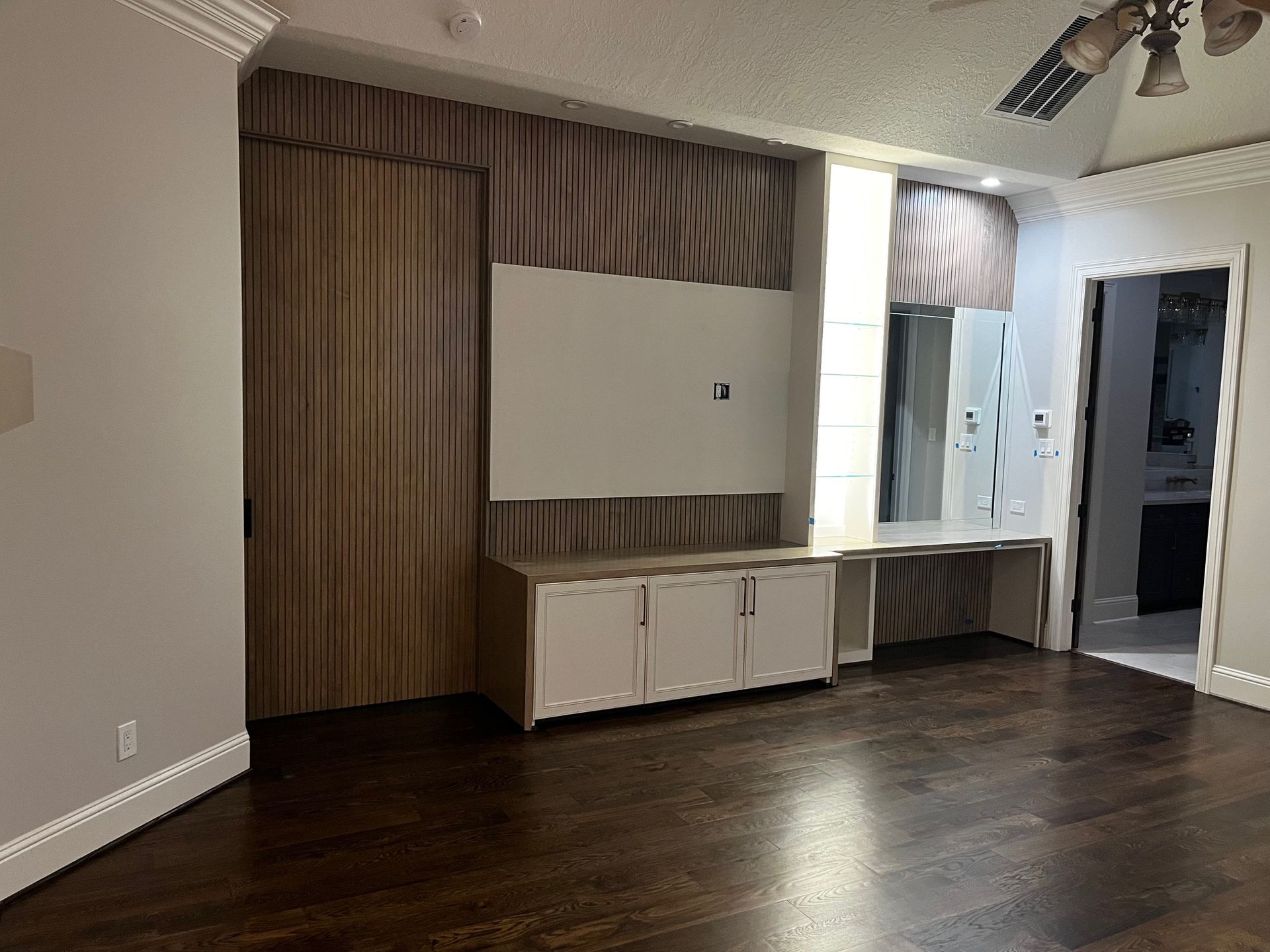 An empty living room with hardwood floors and a ceiling fan.