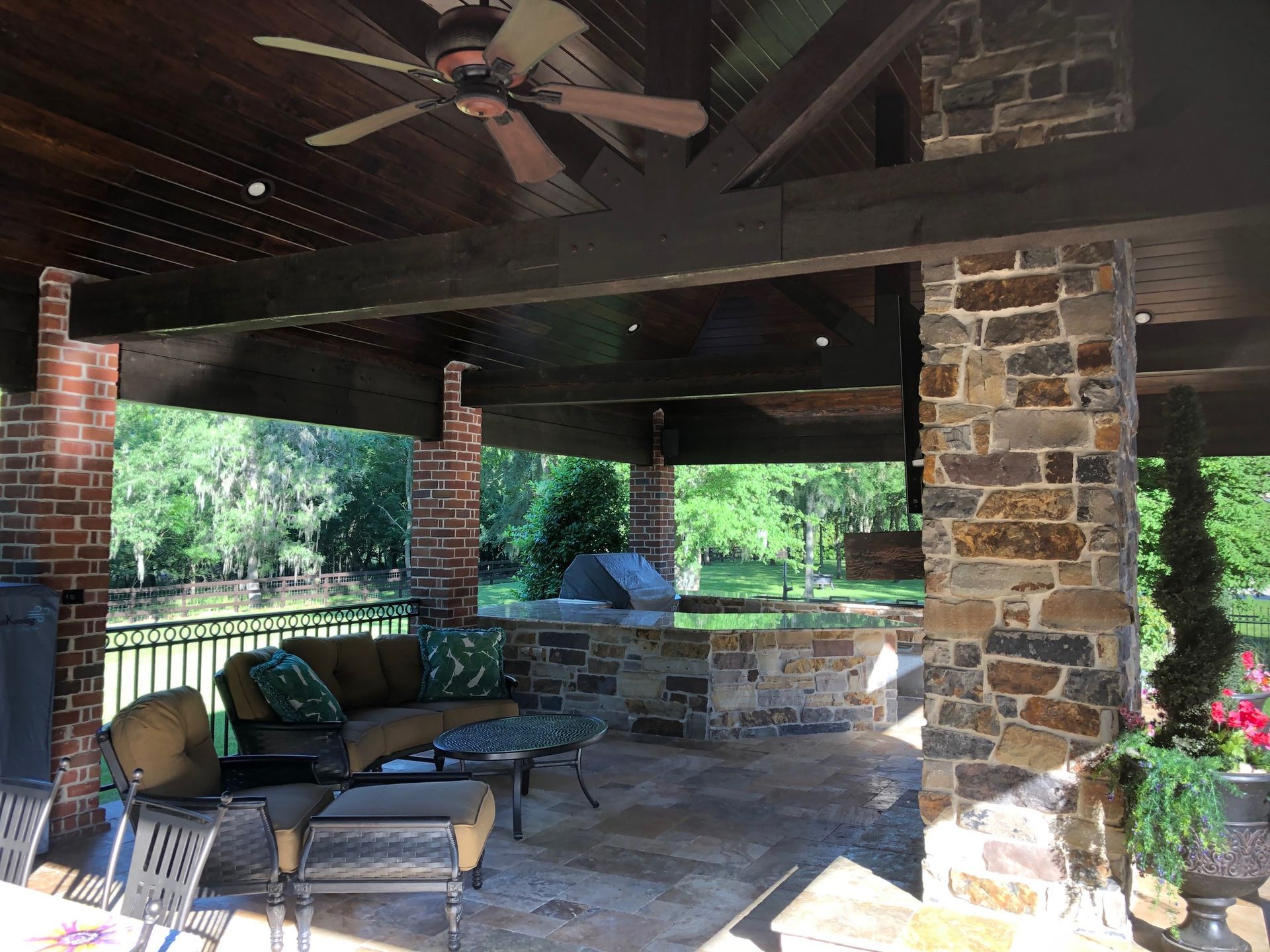 A patio with a ceiling fan and a brick wall