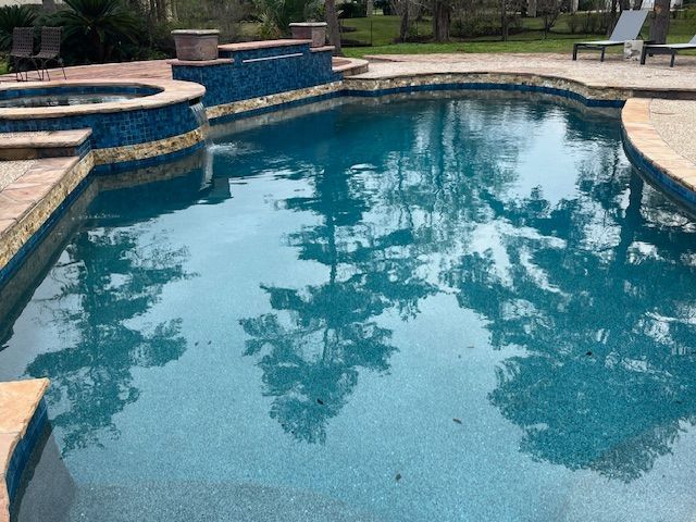 A large swimming pool with trees reflected in the water